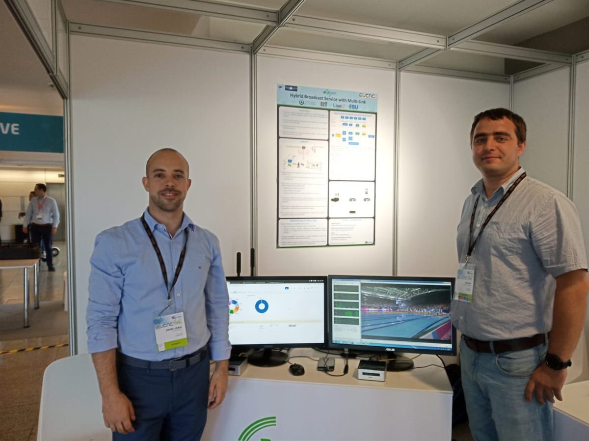 Two people at a conference demo booth with screens