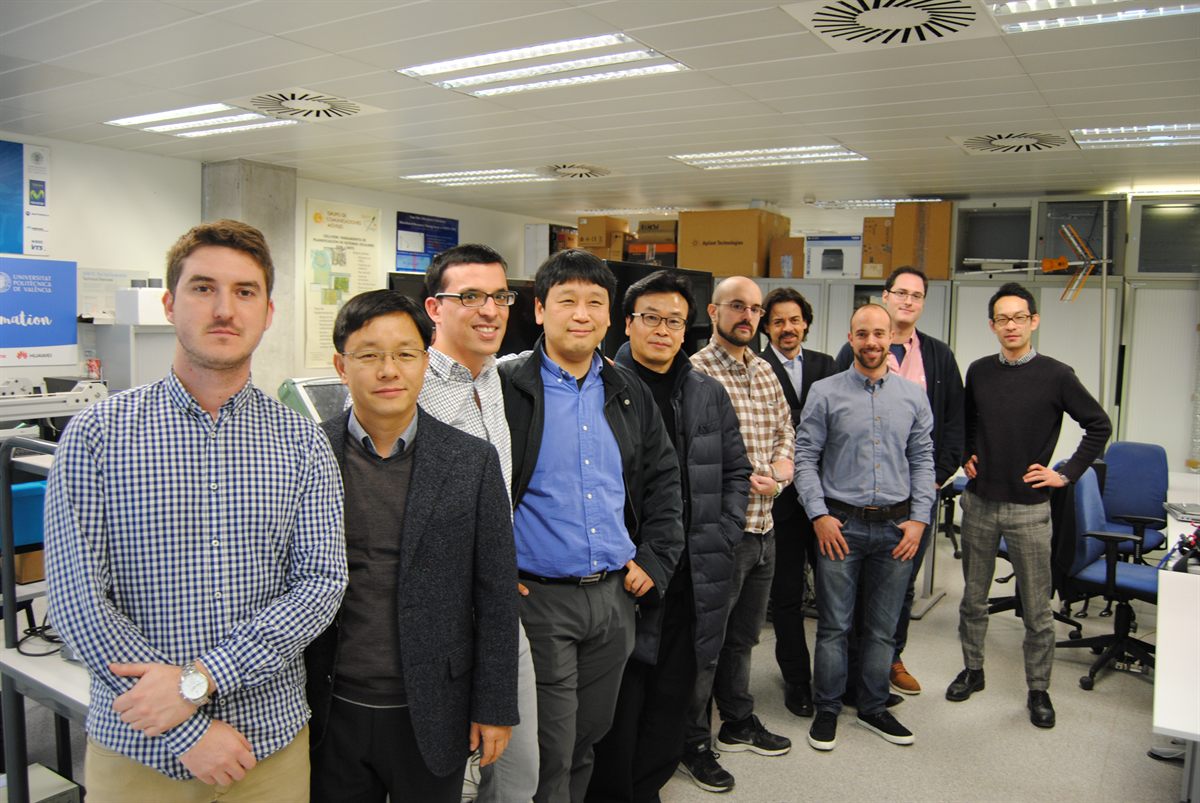 A group of researchers and visitors posing in a lab