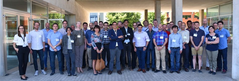 A large group photo of project partners outside a building