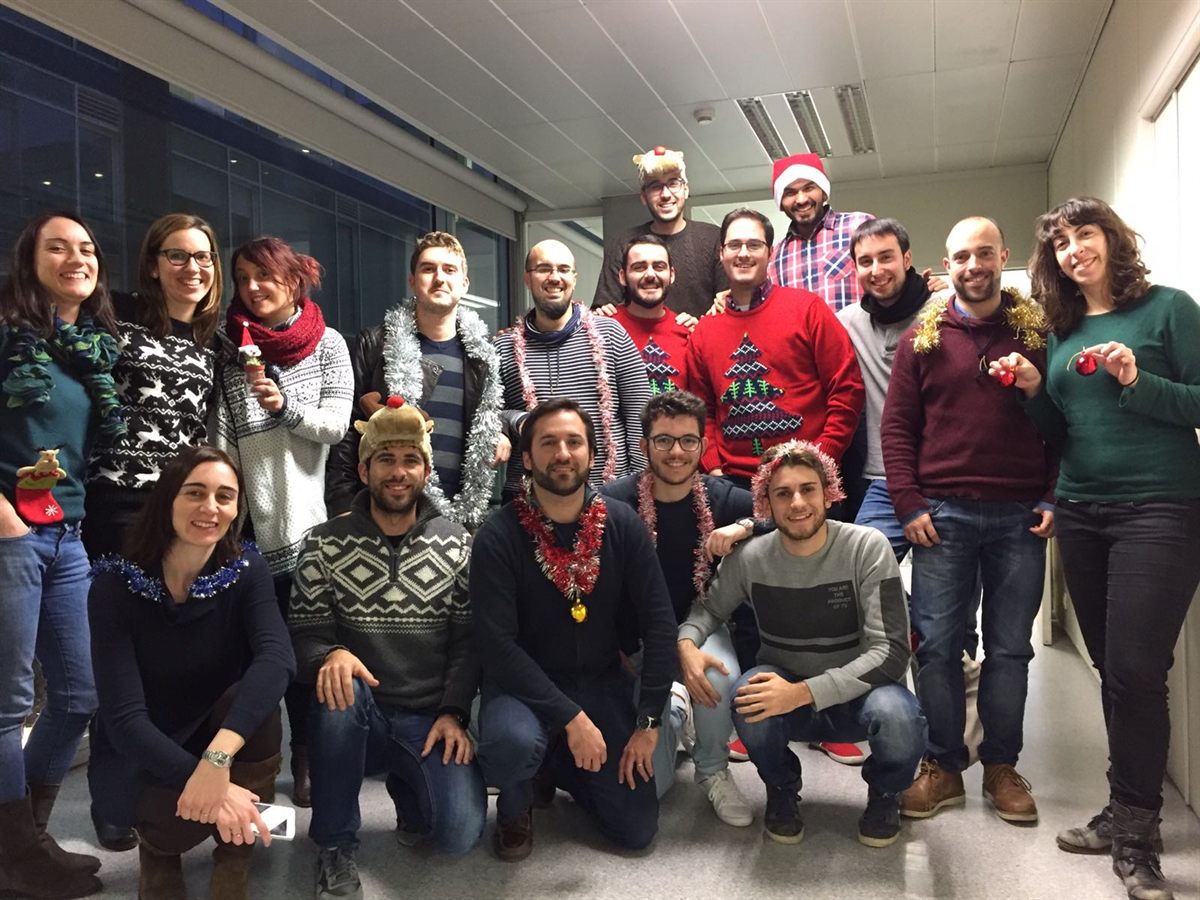 A group in festive jumpers posing for a Christmas photo