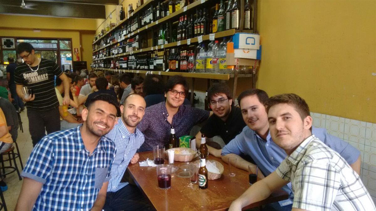Friends smiling around a table in a bar