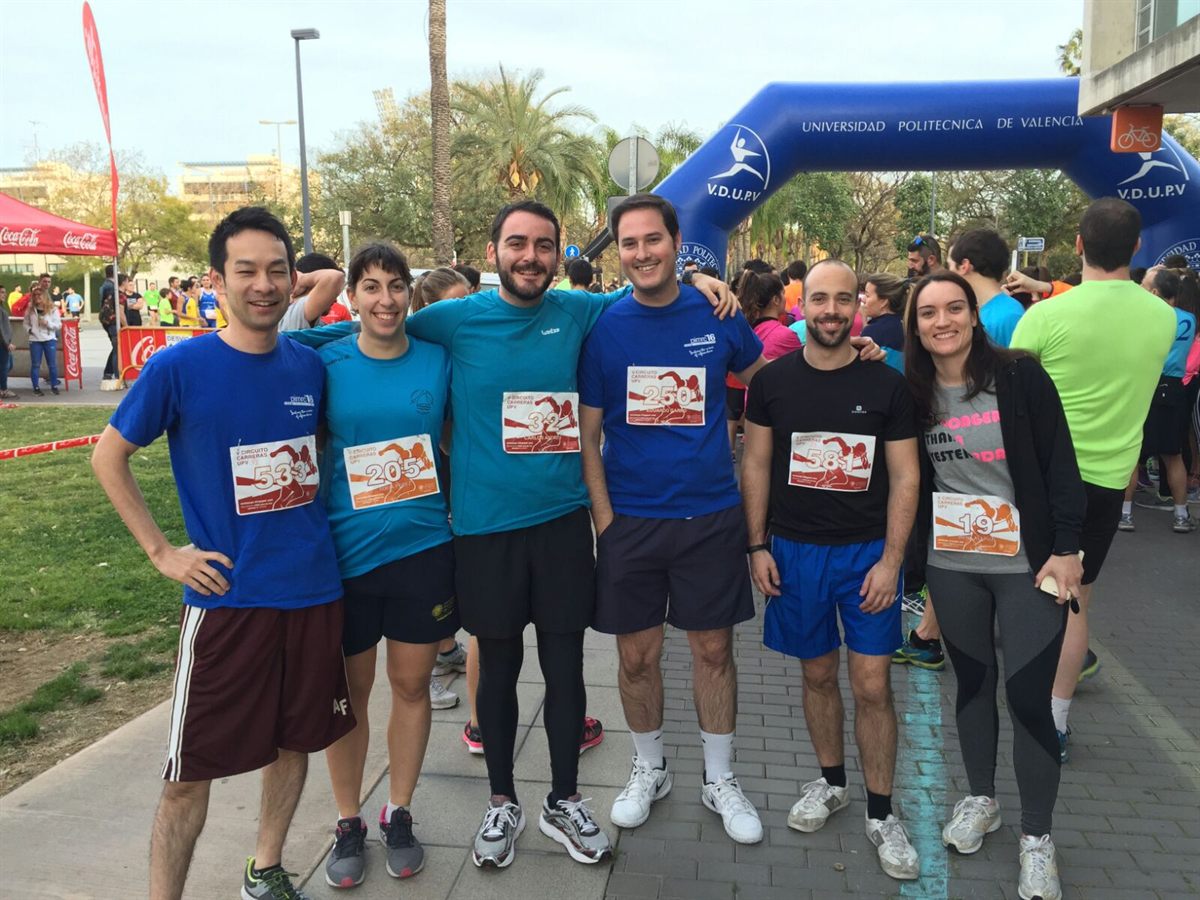 A group in running gear with race numbers at a finish line